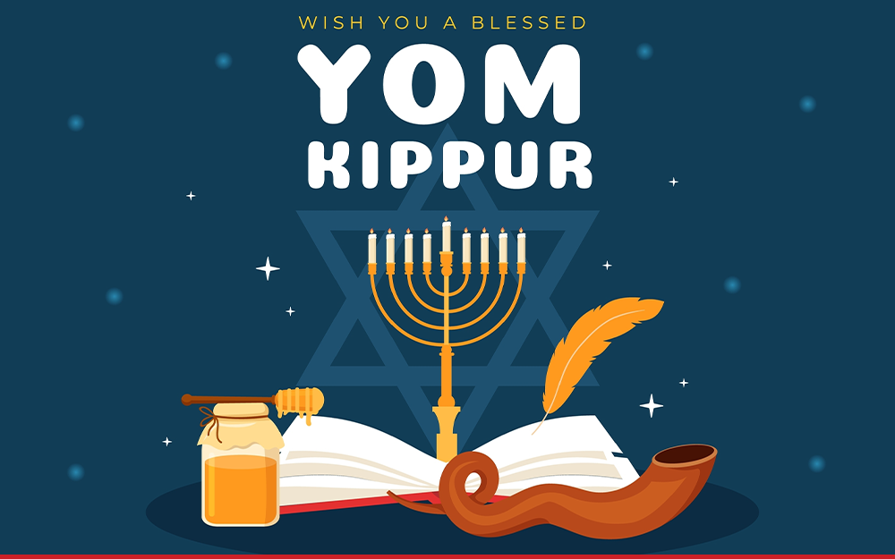 A menorah protrudes from an open book, with text that says "Wish you a blessed Yom Kippur".