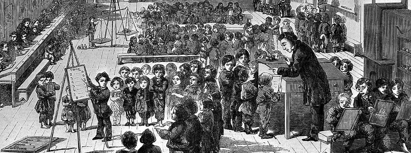 An engraving of Ragged School, Whitechapel. A very large school room full of children, with a teacher at the front presiding over a wooden desk