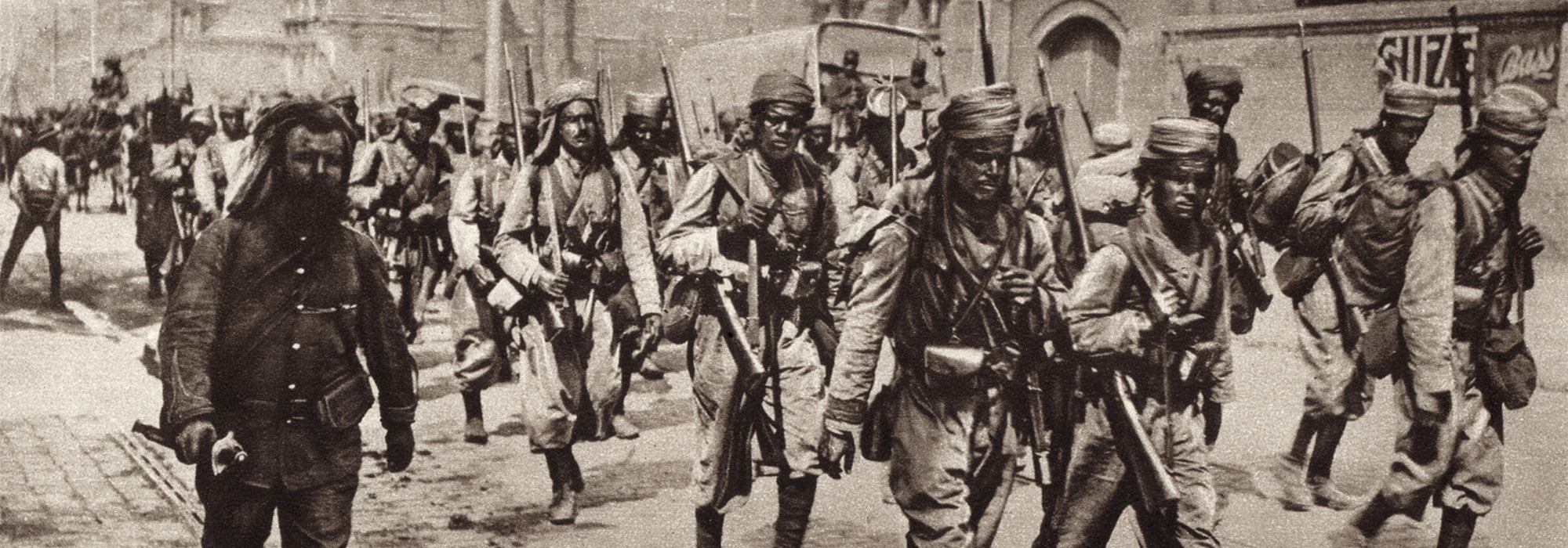 Army of Africa soldiers from Algeria, Tunisia and Morocco included indigenous people and white French colonials. The soldiers are seen marching through the street.