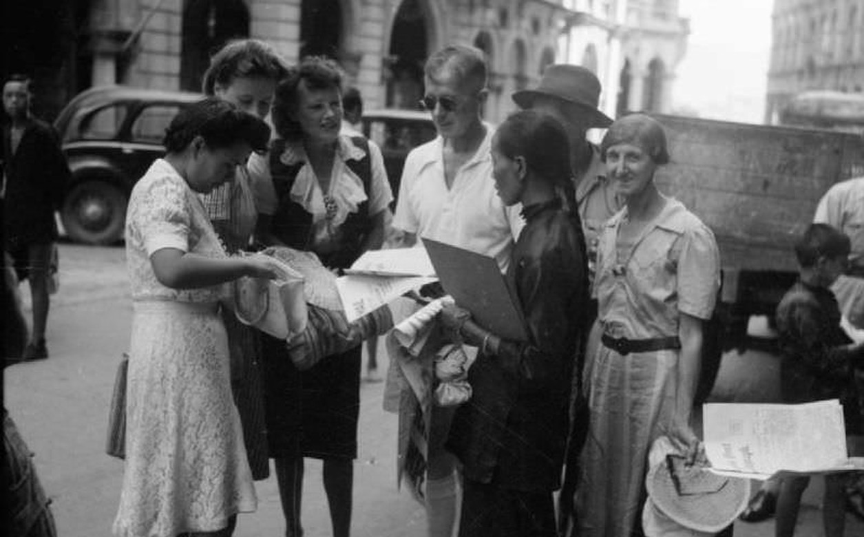 British internees buy their first newspapers on arriving in Hong Kong City after leaving Stanley Civil Internment Camp.