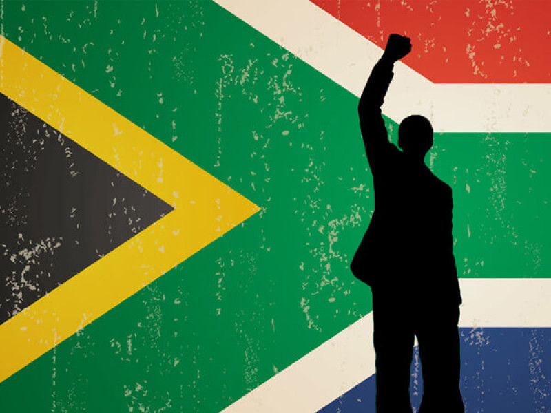 The South African flag with a silhouette of Nelson Mandela overlayed, with his fist in the air.