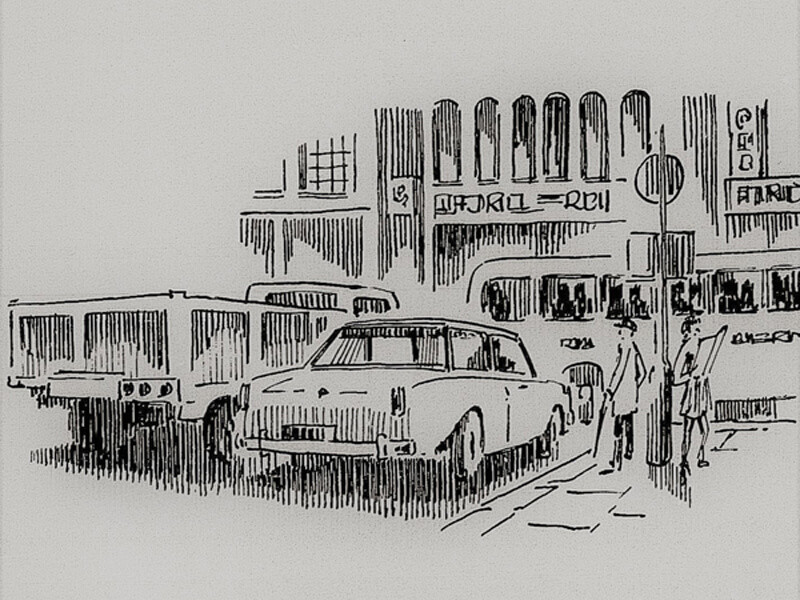 A line drawing sketch of vehicles stopped at a street corner. Two people stand at the corner next to a lamp post.