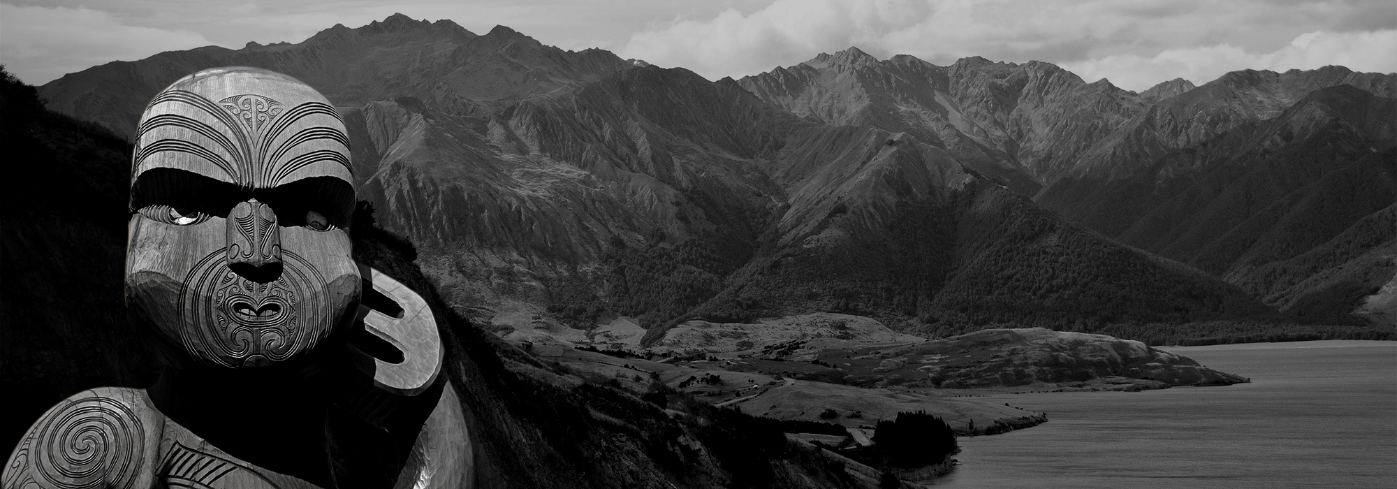 An image of a Māori statue, created by Māori people, who are the indigenous Polynesian people of mainland New Zealand. Behind the statue is a mountain range.