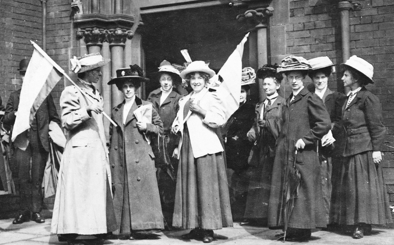 A black and white image of Suffragists demonstrating outside of a police court.
