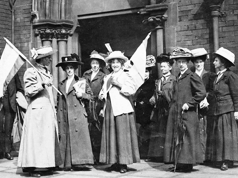A black and white image of Suffragists demonstrating outside of a police court.