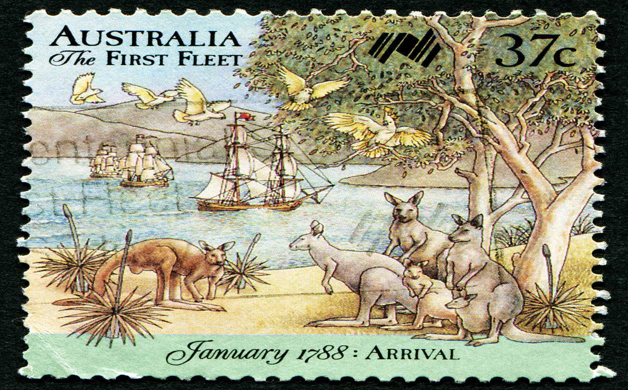 A stamp from Australia 1788, with the text 'The First Fleet'. The image shows boats arriving to the coast of Australia where a group of kangaroos are stood on the beach.