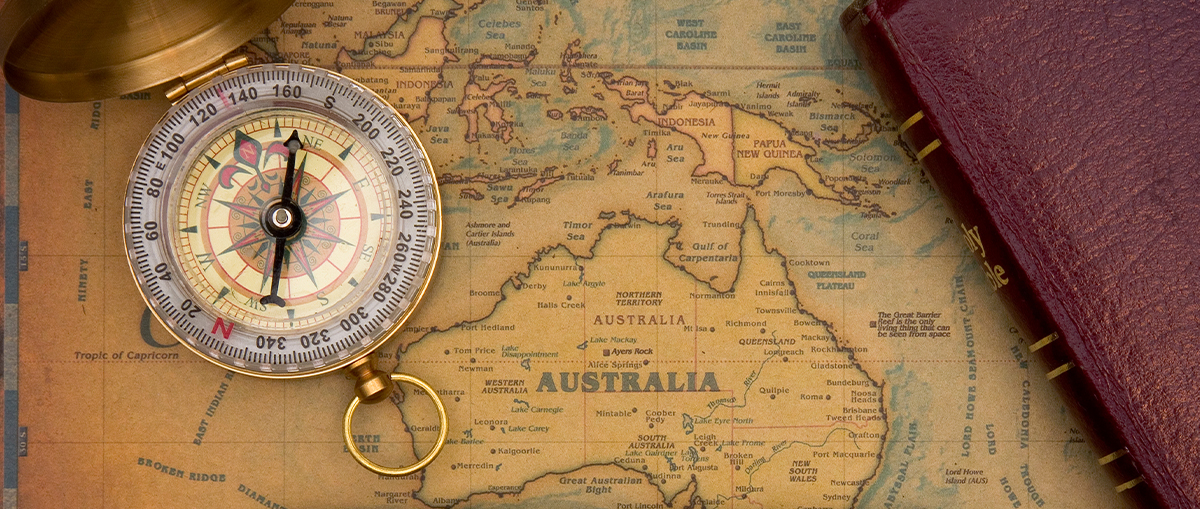 A photograph of a map of Australia with a compass on top.