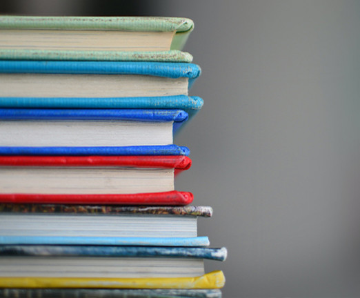 A photo of a pile of books with various coloured covers.