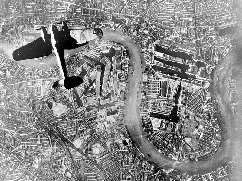 Black and white aerial photograph of a German bomber plane flying over east London.