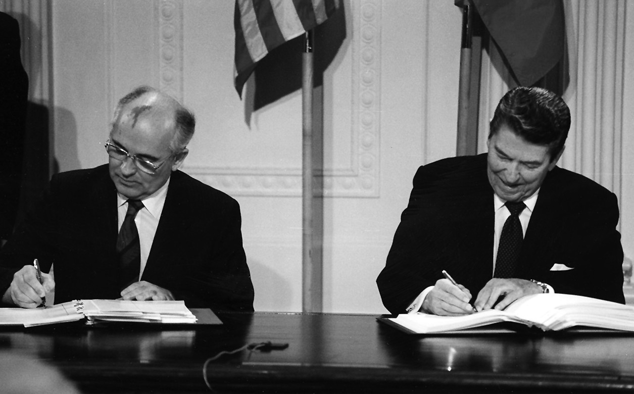 A black and white image of Mikhail Gorbachev and Ronald Reagan signing the INF Treaty.