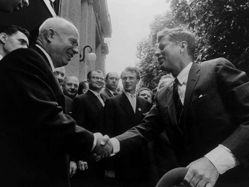 A black and white image of US President John F. Kennedy and First Secretary of the Communist Party of the Soviet Union (CPSU) Nikita Khrushchev meeting and shaking hands in Vienna.