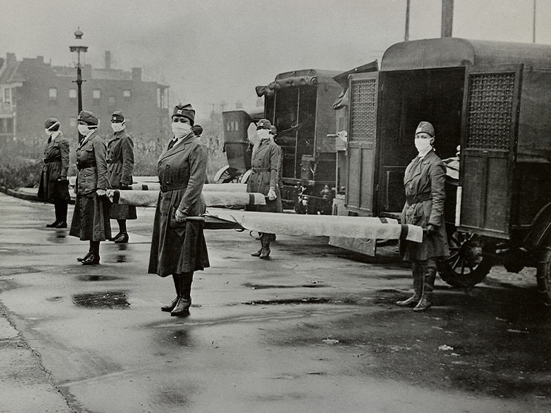 A black and white image of nurses wearing masks.