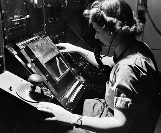 A photograph of WAAF radar operator Denise Miley plotting aircraft on a cathode ray tube in the Receiver Room at Bawdsey 'Chain Home' station, May 1945.