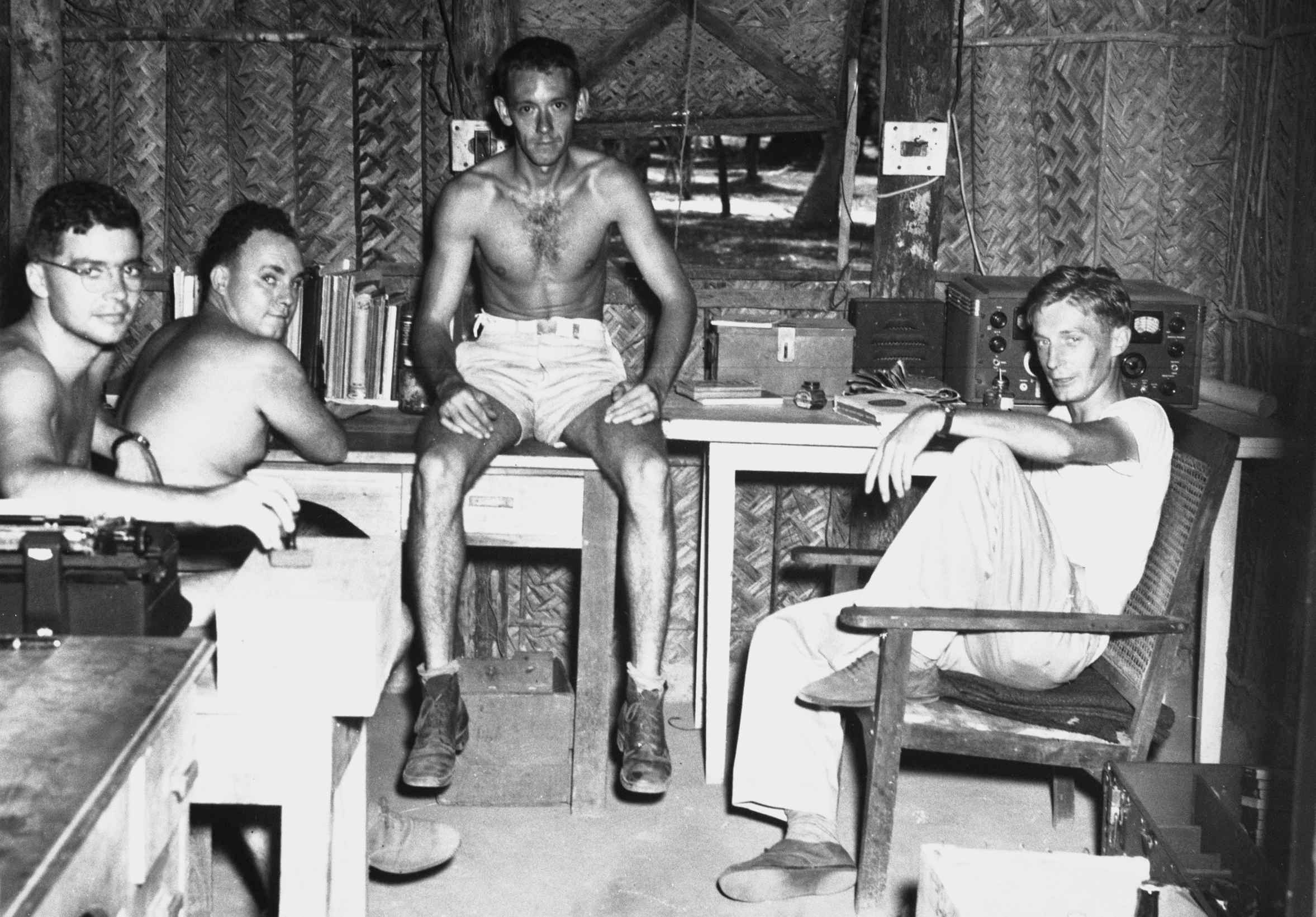 A black and white photo of four men sitting together.