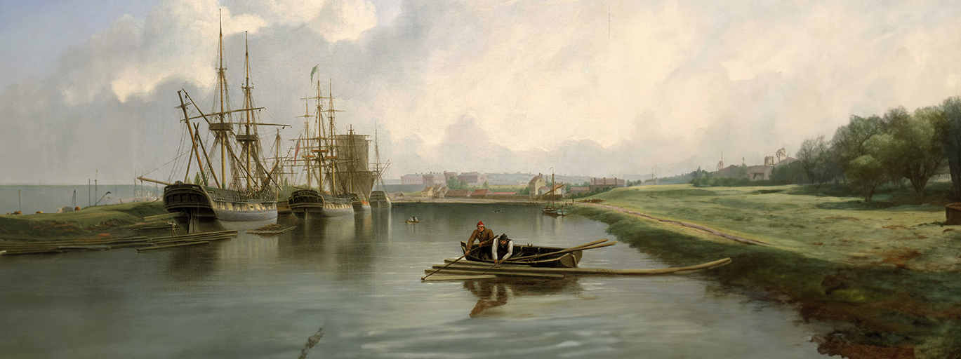 A painting showing West Indiamen alongside Bristol docks on the Avon. The ship in the foreground on the left is being unloaded with timber from America. Some of the unloaded timber floats on the water. A man can be seen standing on a pile of floating planks as one of them is being lowered down from the ship. A figure leans over the stern to manage the process. The ship may be having her mast stepped. There is another pile of wooden planks floating on the starboard side of the ship. Two men in a rowing boat are using a pole and hook to catch a smaller pile of planks floating in the foreground on the right. The barge on the right is a Severn trow which conveyed a lot of cargo up and down the river, and, as in this painting, would have brought iron down the Severn.
