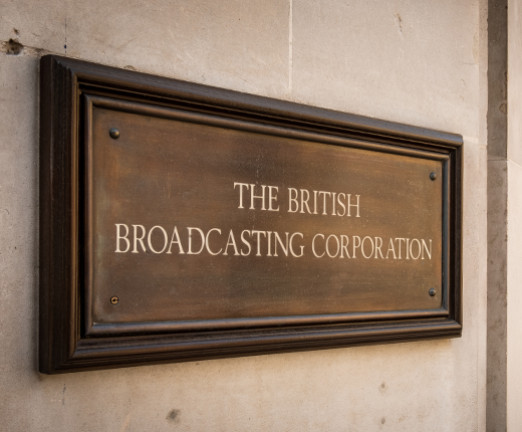 A brown plaque on a wall that reads The British Broadcasting Corporation.