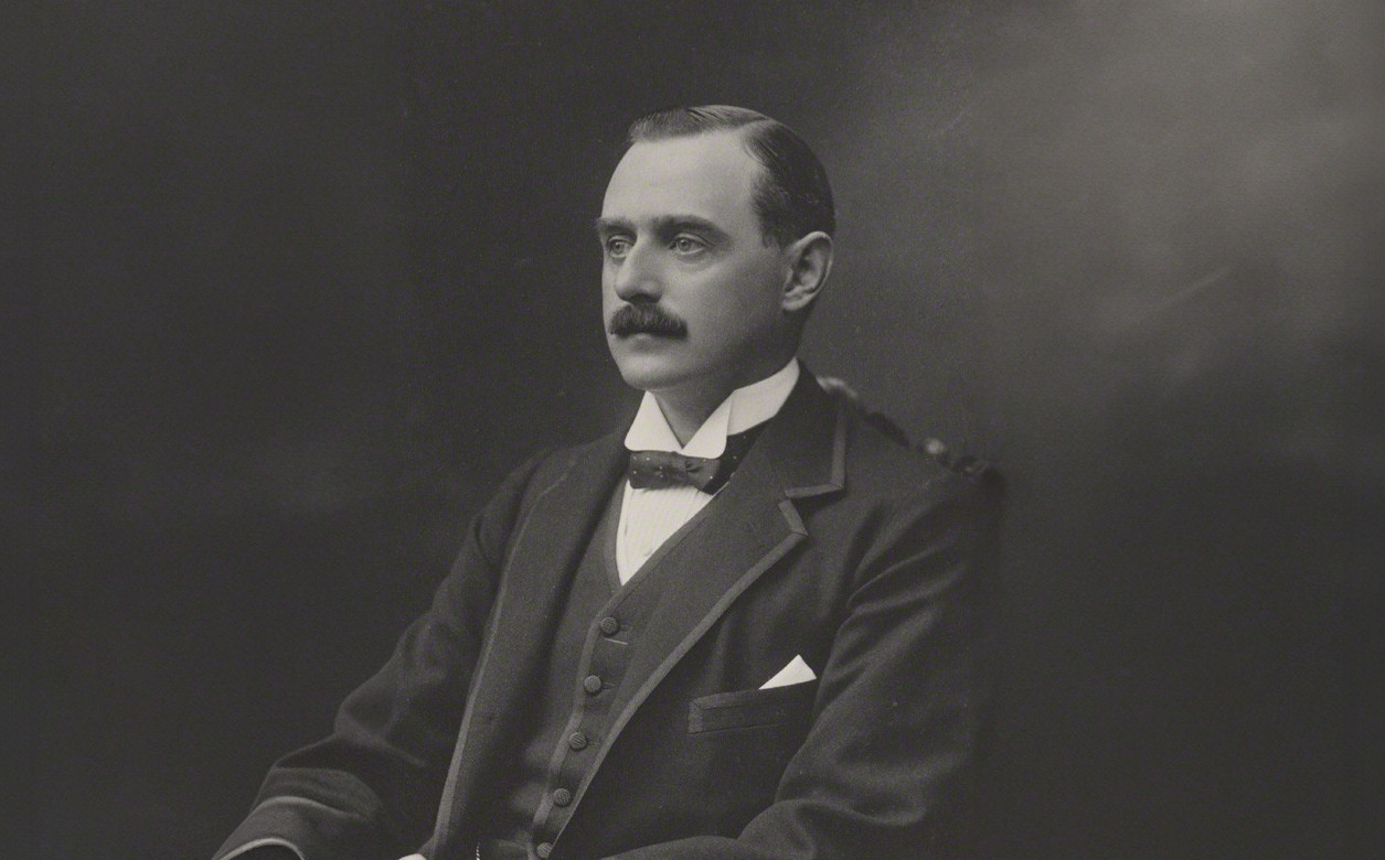 A photograph of Arthur Murray, sat in a chair and looking into the distance.