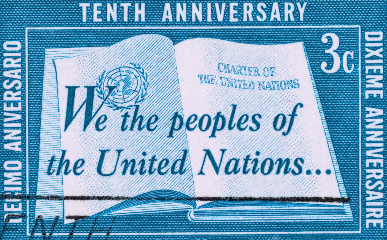 Blue United Nations stamp, with the text "We the peoples of the United Nations..."