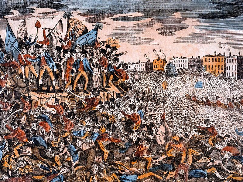 An illustration of the Peterloo Massacre (1819). A group of people stand on a platform holding banners on the left. Beneath them officers on horseback wield swords, and several figures lie dead and injured on the floor. A large crowd features on the right.