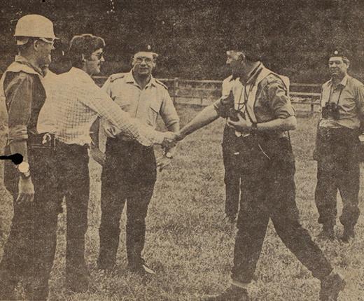 Greyscale photograph of Major Robert Manley shaking hands with a civilian pilot.