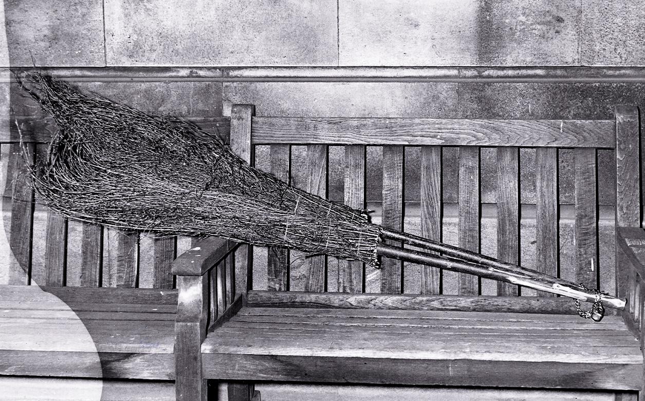 A photograph of two broomsticks chained to a bench.